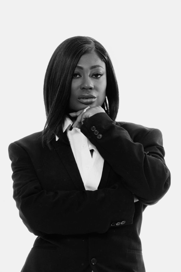 Christlie Jean-Baptiste in a black blazer, resting her chin on her hand